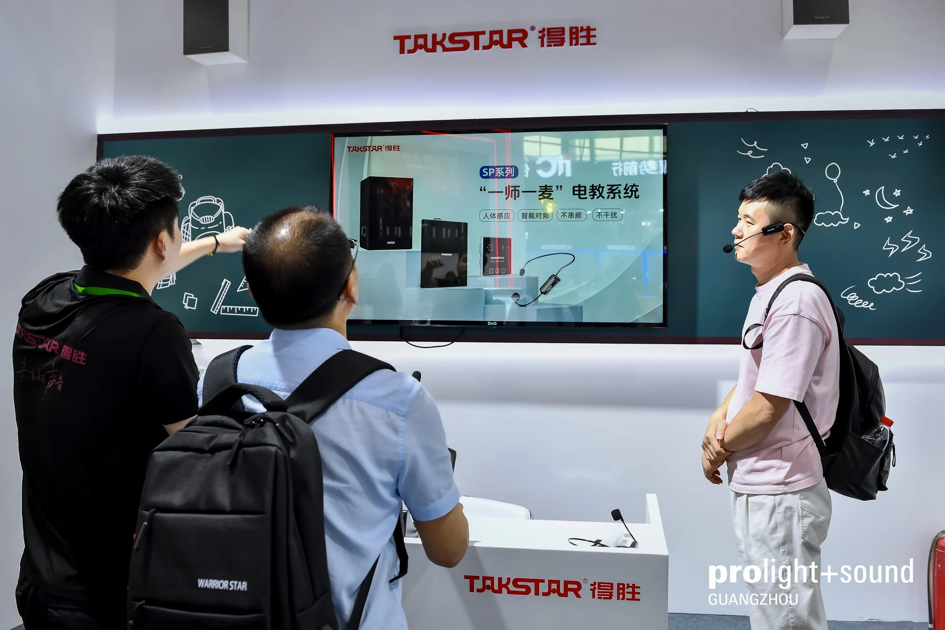 Exhibition stand with interactive display, visitors see product presentation on large screen