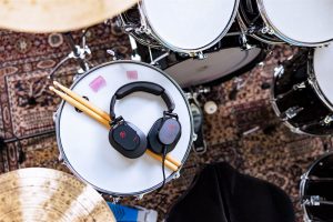 Schlagzeug mit Kopfhörern und Drumsticks auf der Snare, von oben fotografiert.