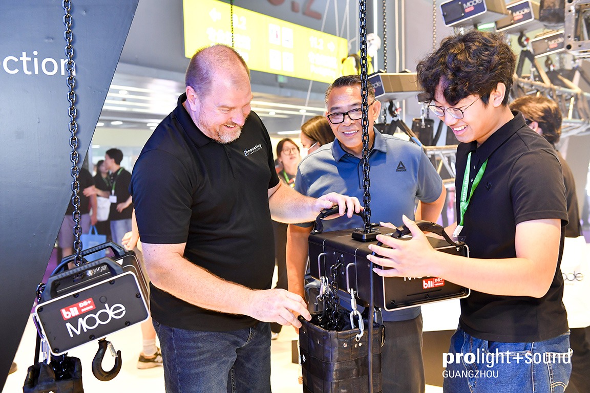 Visitors test lifting and rigging equipment at an exhibition stand