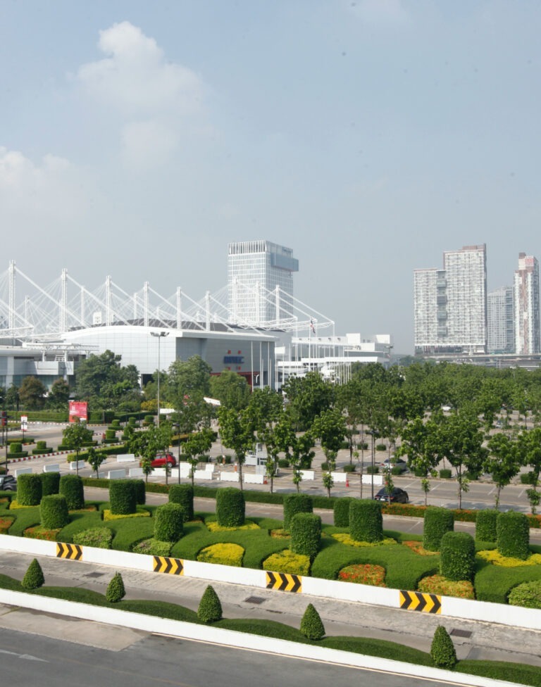 Weitblick auf das BITEC-Gelände mit Skyline und gepflegter Grünanlage in Bangkok