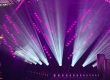 Violette und weiße Lichtstrahlen inszenieren eine Bühne mit dynamischen Effekten.