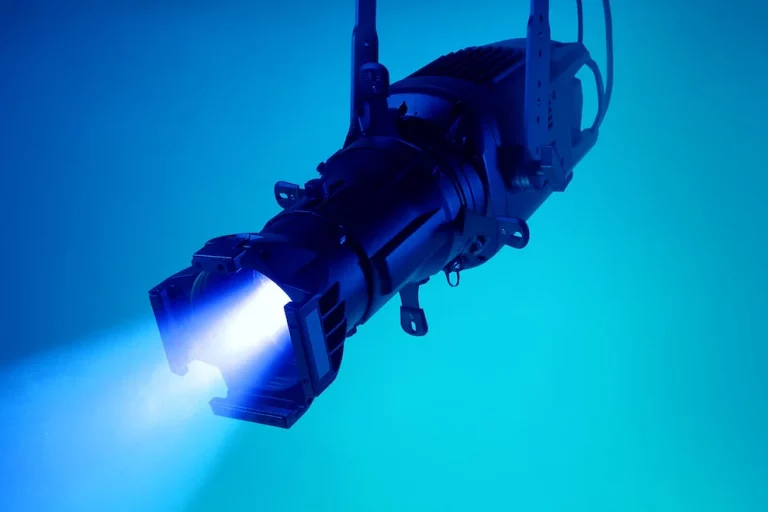 Elation KL Core IP Ein schwarzer LED-Scheinwerfer strahlt einen intensiven blauen Lichtkegel aus.