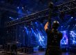 Techniker beim Aufbau einer Bühnentraverse mit Lichttechnik und blauer Showbeleuchtung