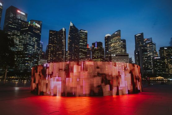 Leuchtende Lichtinstallation vor der nächtlichen Skyline von Singapur