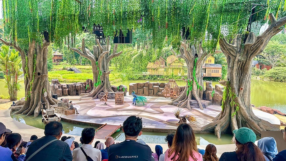 Freilichttheater mit Publikum und Bühne inmitten tropischer Vegetation