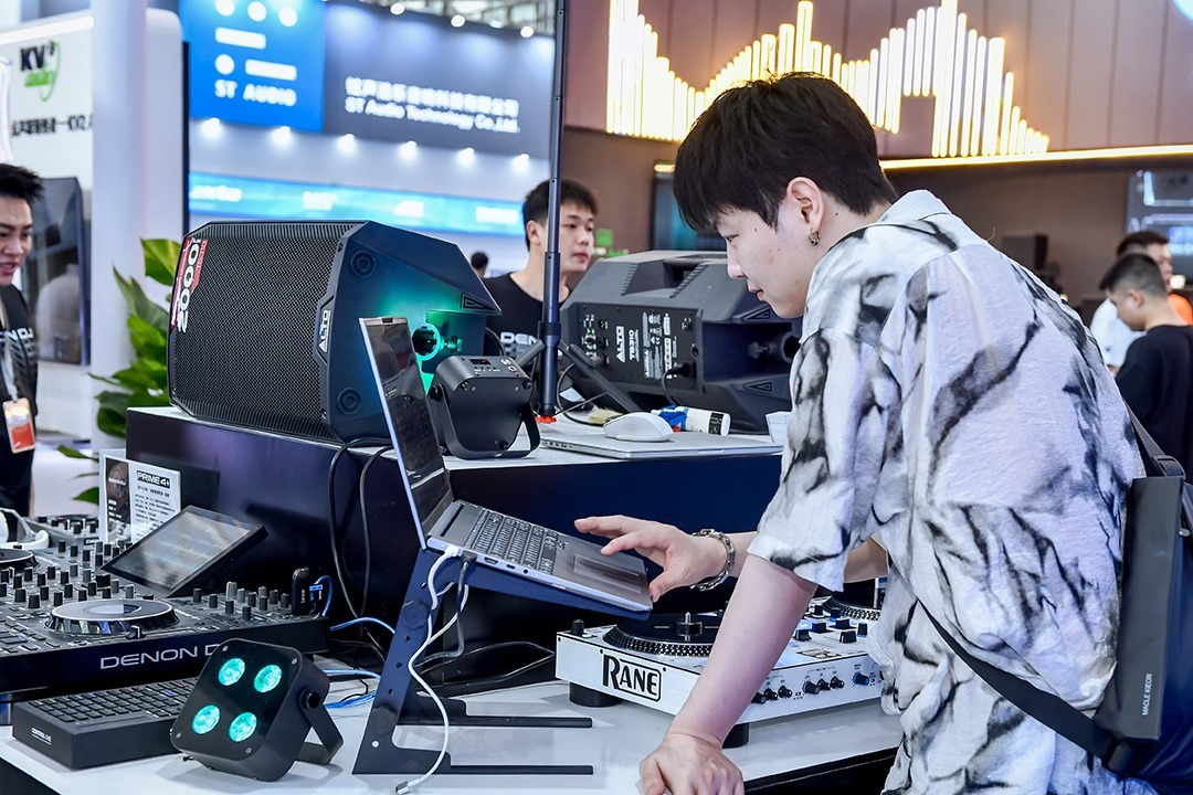 Besucher testet DJ-Equipment und Software an einem interaktiven Messestand