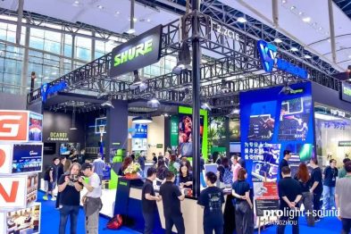 Messestand von Shure mit Fachbesuchern, Displays und Traversenkonstruktion