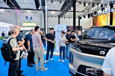 Besuchergruppe vor Fahrzeugen und Bühnentechnik auf der Prolight + Sound Guangzhou