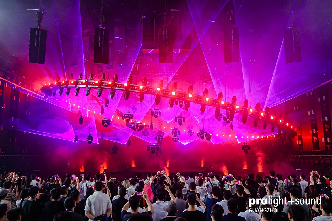 Audience watching a spectacular light show featuring lasers, fog and suspended speakers