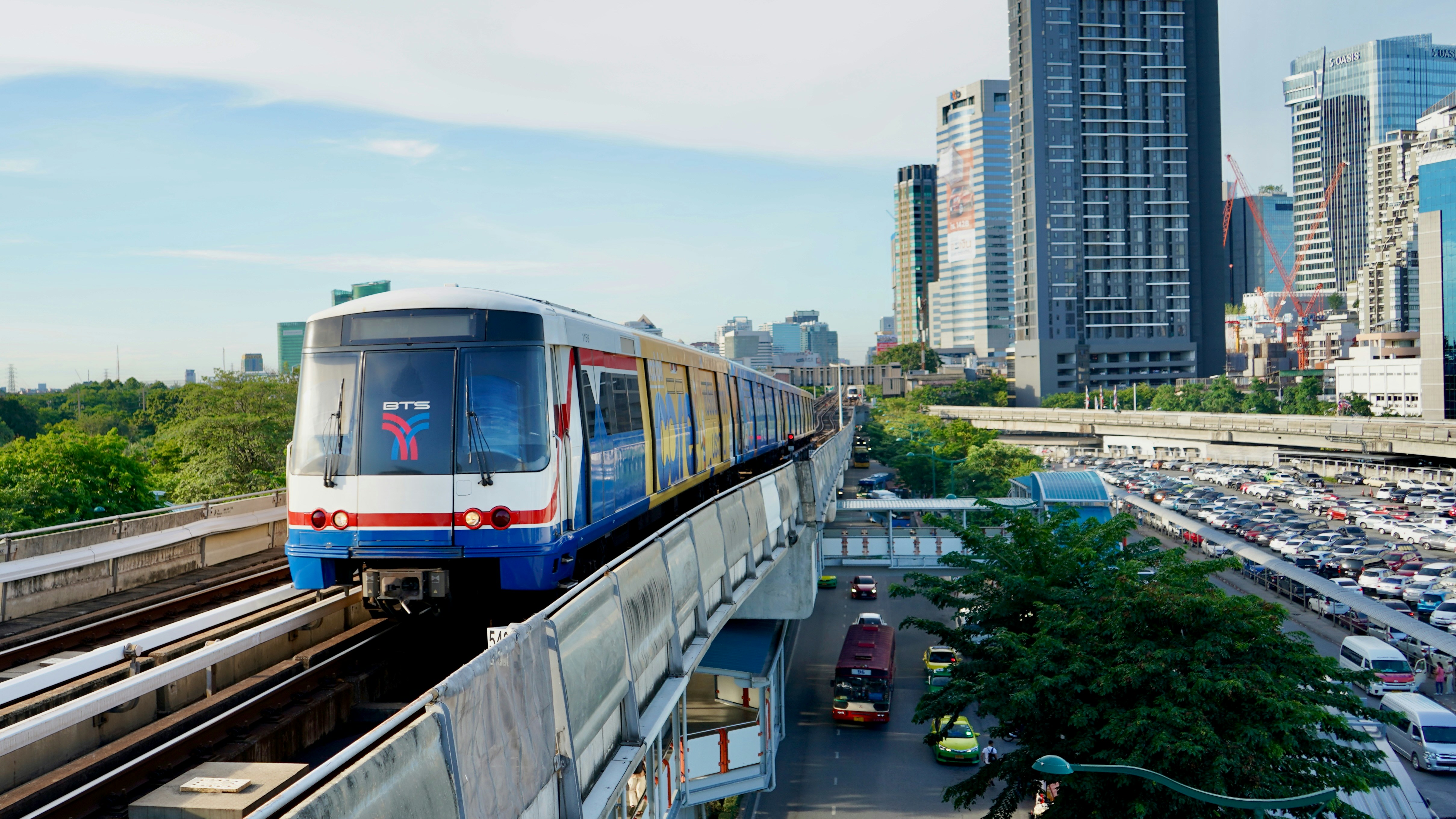 BTS-Skytrain in Bangkok vor Hochhäusern und Stadtverkehr.